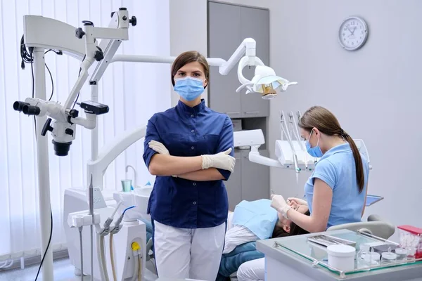 Portret van jonge vrouwelijke arts tandarts in medisch gezichtsmasker in tandheelkundig kantoor — Stockfoto