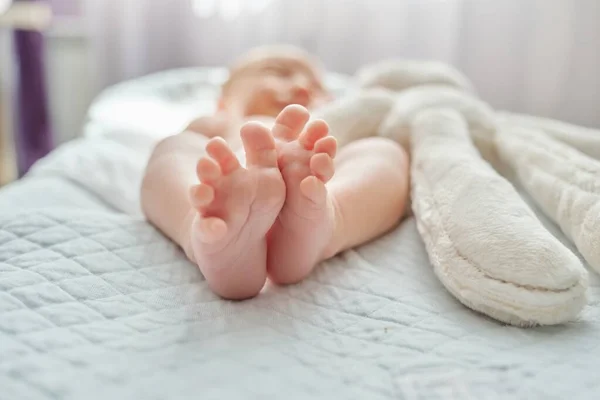 Close up of feet of newborn baby lying on blanket — Stock Photo, Image