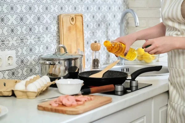 Giovane bella donna che cucina a casa in cucina, fritture uova con salsicce — Foto Stock