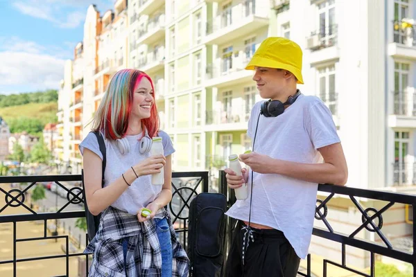 Glada talande studenter tonåringar i staden dricka mjölk yoghurt från flaska — Stockfoto