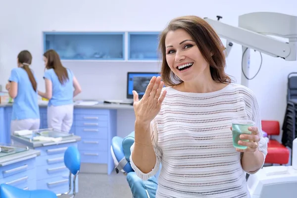 Gelukkig volwassen vrouw patiënt in tandheelkundig kantoor glimlachen met wit gezond tanden — Stockfoto