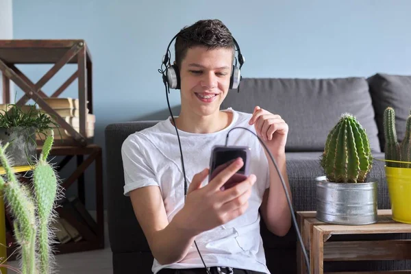 Мальчик-подросток в наушниках со смартфоном делает видеозвонок — стоковое фото