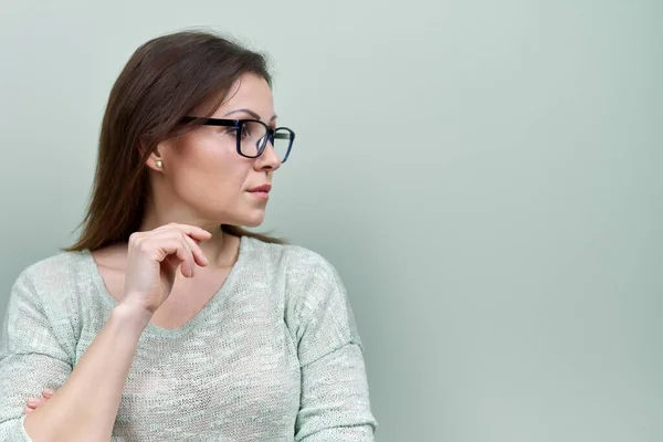 Portrait de femme mature triste seule avec des lunettes sur fond vert — Photo