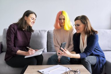 Sosyal hizmet görevlisi, psikolog olgun bir kadın ve genç kızıyla görüşüyor.