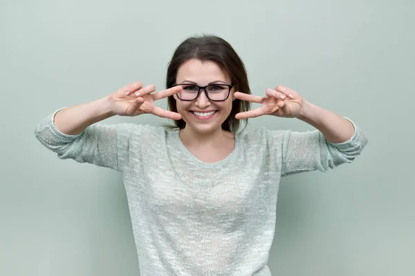 Happy mature confident woman showing victory symbol with hand gesture — Stock Photo, Image