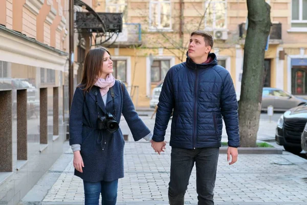 Utomhus porträtt av lyckliga par i kärlek promenader längs gatan i staden hålla händer — Stockfoto