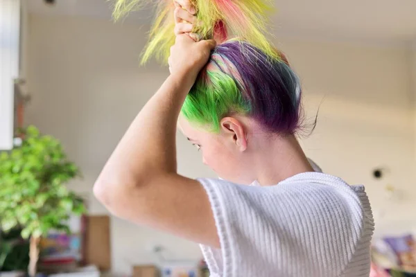 Modische Teenie-Mädchen mit trendigen regenbogengefärbten Haaren kämmen die Haare zu Hause — Stockfoto