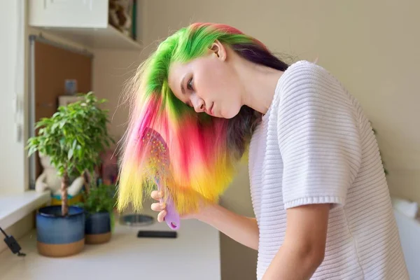 Chica adolescente de moda con el pelo teñido arco iris de moda peinar el pelo en casa — Foto de Stock