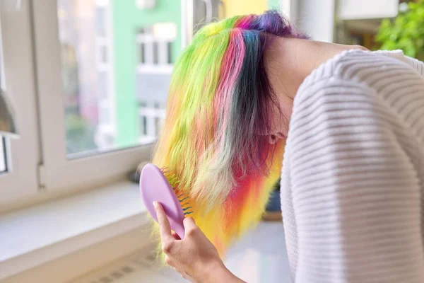 Chica adolescente de moda con el pelo teñido arco iris de moda peinar el pelo en casa — Foto de Stock