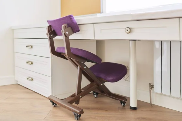 Orthopedic knee chair in the interior of childrens room, home office
