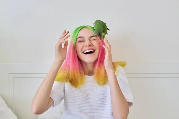 Moda de moda con peinado de color adolescente con loro verde en la cabeza — Foto de Stock