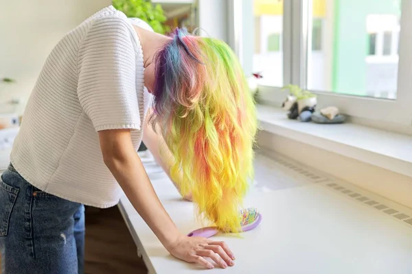 Módní teen dívka s módní duhou barvené vlasy česání vlasy doma — Stock fotografie