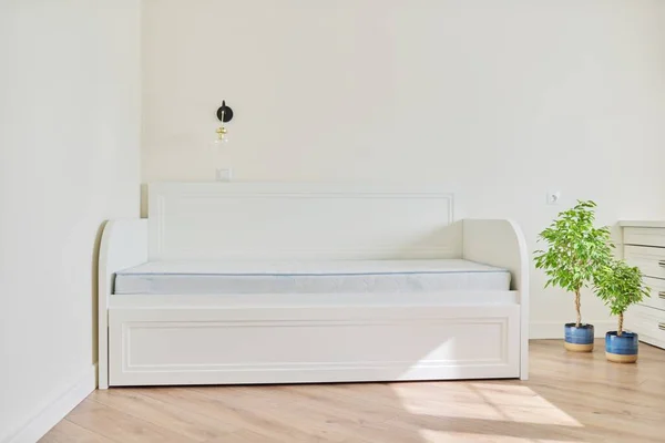 Białe nowe drewniane wygodne łóżko z materacem dla dziewczyny w pustym pokoju — Zdjęcie stockowe