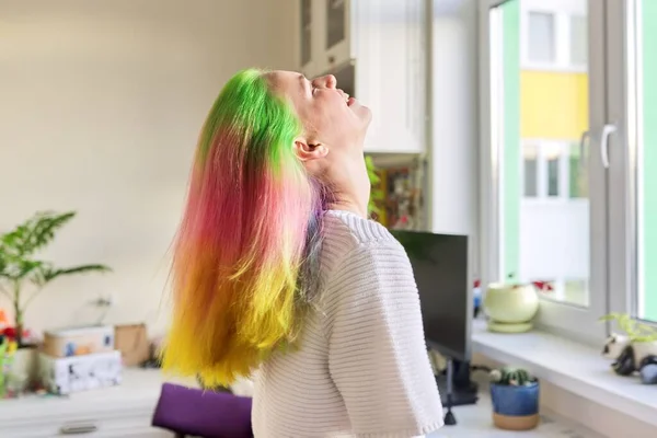 Modieus tienermeisje met trendy regenboog geverfd haar kammen haar thuis — Stockfoto