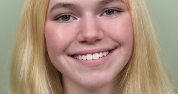 Linda adolescente menina loira sorrindo com os dentes olhando para a câmera — Vídeo de Stock