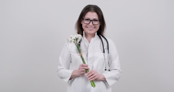 Sonriente enfermera doctora madura con ramo de flores, regalo, celebración, día del trabajador médico — Vídeos de Stock