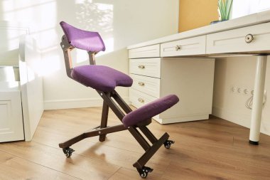 Ortopedik ergonomik diz çökme sandalyesi çocuk odasının içinde, merkez ofiste.