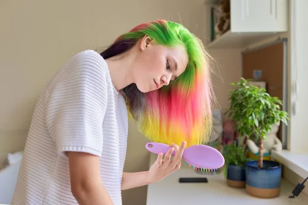 Menina adolescente na moda com cabelo tingido de arco-íris moderno pentear o cabelo em casa — Fotografia de Stock