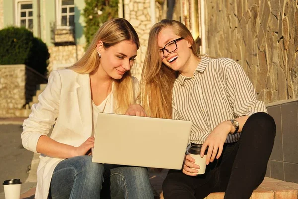 Due giovani belle donne si divertono a guardare nel monitor del computer portatile — Foto Stock