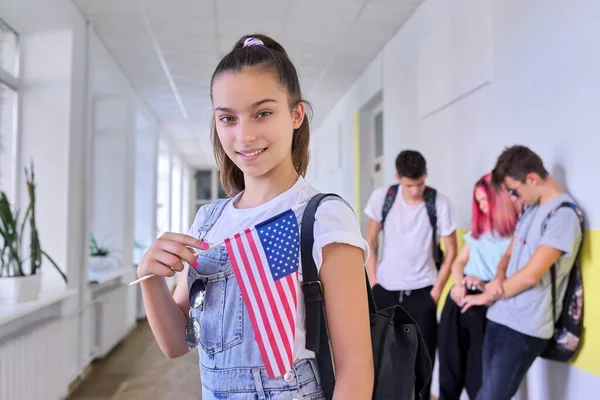 Student teenager girl with USA flag inside school, school children group background — Stock Photo, Image