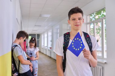 Üniversitede AB bayrağı taşıyan erkek öğrenci, bir grup öğrenci