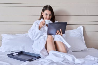 Olgun, güzel bir kadın otelde dinleniyor.