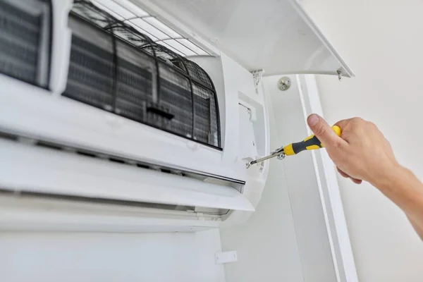 Installing an air conditioner in an apartment office, close-up of an engineer hand