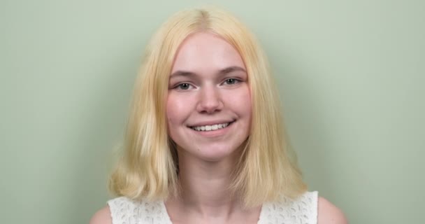 Vacker tonåring flicka blond leende med tänder tittar på kameran — Stockvideo