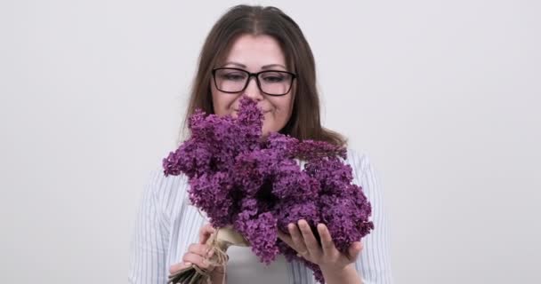 Mulher de meia-idade feliz com buquê de flores no fundo branco — Vídeo de Stock
