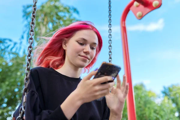 Chica adolescente feliz de moda con el pelo teñido con el oscilación del montar del teléfono inteligente — Foto de Stock