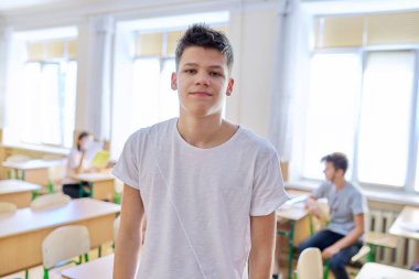 Sınıfta el kol hareketi yapan ergen öğrenci konuşuyor.