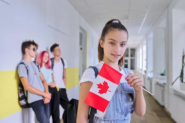 Okulun içinde Kanada bayrağı taşıyan genç kız öğrenci. — Stok fotoğraf