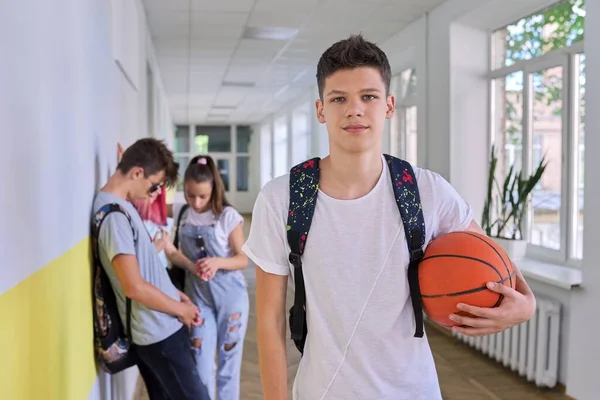 Diák tinédzser srác portréja kosárlabdával és hátizsákkal az iskolaépületben — Stock Fotó
