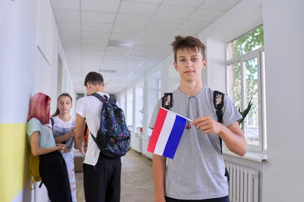Étudiant adolescent mâle avec drapeau néerlandais à l'intérieur de l'école — Photo