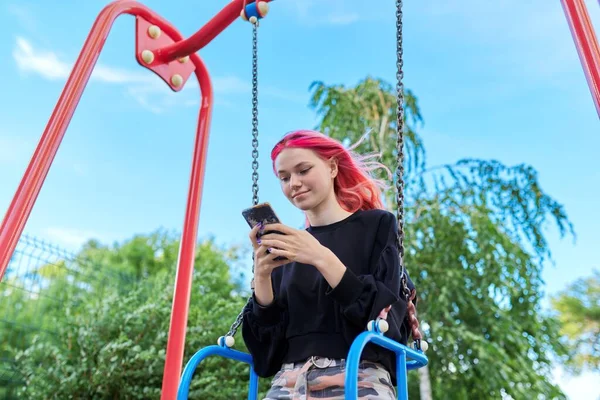 Chica adolescente feliz de moda con el pelo teñido con el oscilación del montar del teléfono inteligente — Foto de Stock