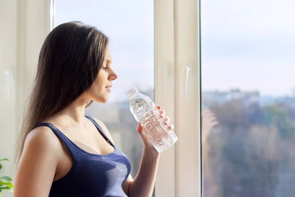 Young beautiful pregnant woman drinking water from bottle — Stock Photo, Image