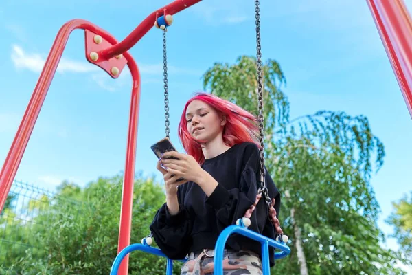 Chica adolescente feliz de moda con el pelo teñido con el oscilación del montar del teléfono inteligente — Foto de Stock