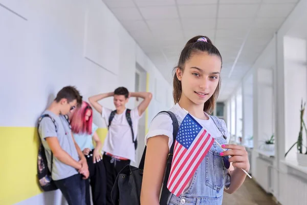 Student teenager girl with USA flag inside school, school children group background — Stock Photo, Image