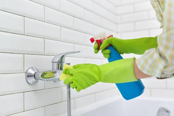 Pulizia bagno, donna lavaggio piastrelle parete e miscelatore con panno con detergente — Foto Stock