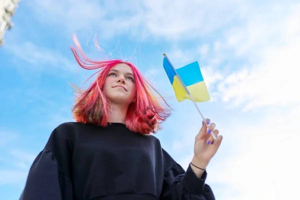 Žena student teenager s vlajkou Ukrajiny, modrá obloha s mraky pozadí — Stock fotografie