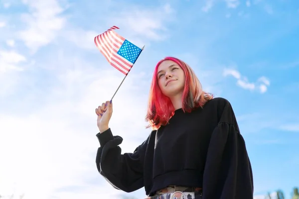 Female student teenager with USA flag in hand, blue sky with clouds background. — Stock Photo, Image