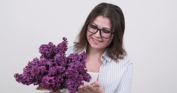 Szczęśliwa kobieta w średnim wieku z bukietem kwiatów na białym tle — Wideo stockowe