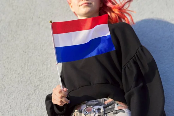 Student girl teenager with the flag of the Netherlands in hand