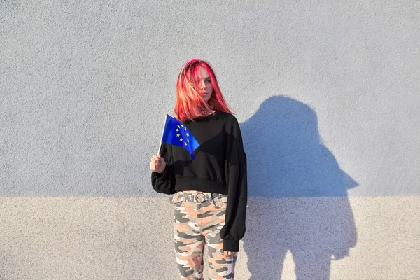 Női diák tinédzser EU zászló a kezében, szürke szabadban fal háttér — Stock Fotó