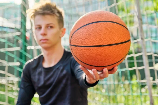 Primer plano pelota de baloncesto en la mano de un adolescente — Foto de Stock