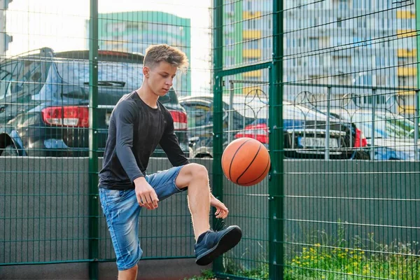 Outdoor portrait of teenage boy playing street basketball — Stock Photo, Image