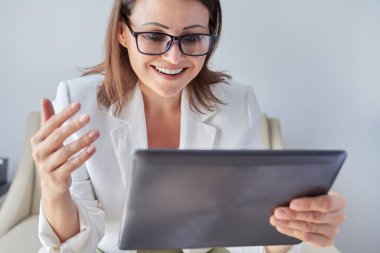 Kadın psikolog, psikiyatrist webcam dijital tabletine bakıyor.
