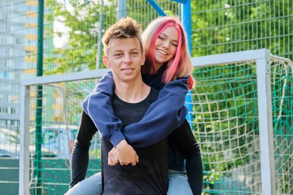 Couple of teenagers guy and girl having fun on an outdoor basketball court — Stock Photo, Image