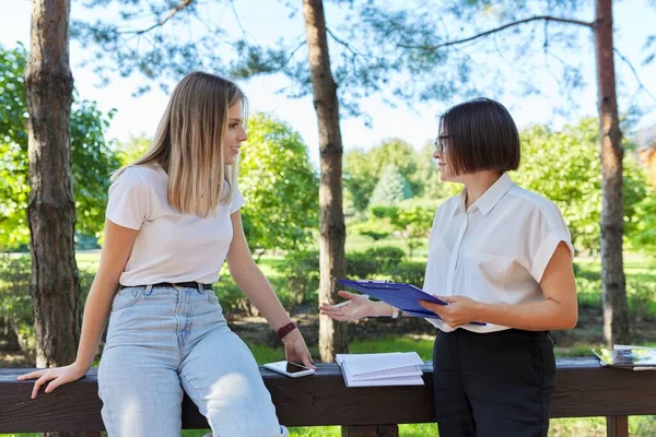 Γυναίκα έφηβη φοιτήτρια μιλάει με δάσκαλο, κοινωνική λειτουργό, κάθεται στο πάρκο — Φωτογραφία Αρχείου