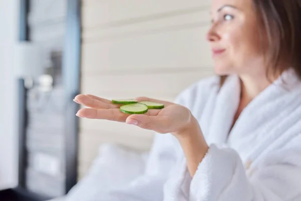 Gammal kvinna i badrock som gör spabehandlingar med gurka — Stockfoto